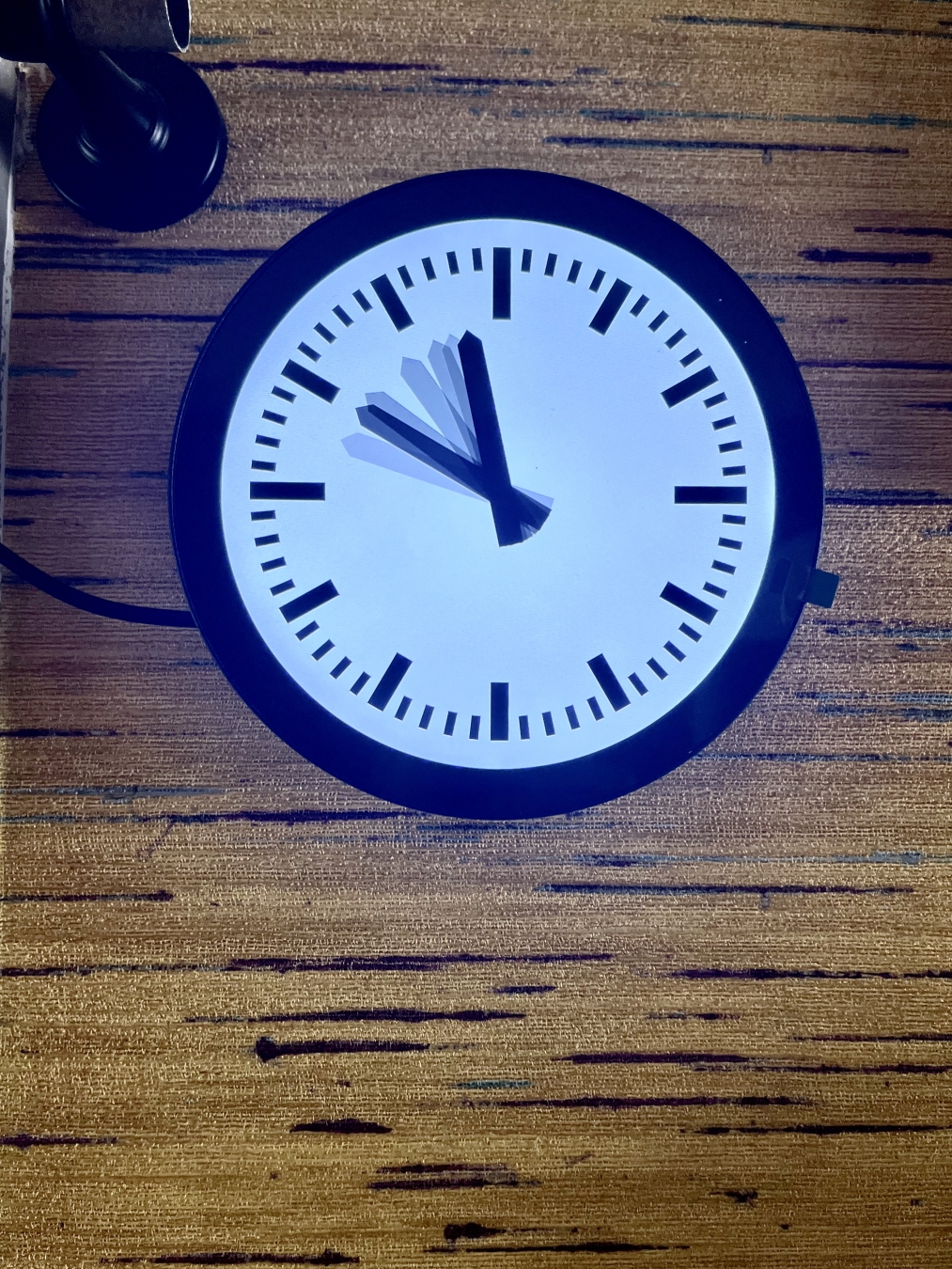 A clock with only an hour hand. Or better, quite a few hour hands, with different levels of opacity, that show that the time is somewhere between 10 and 12.